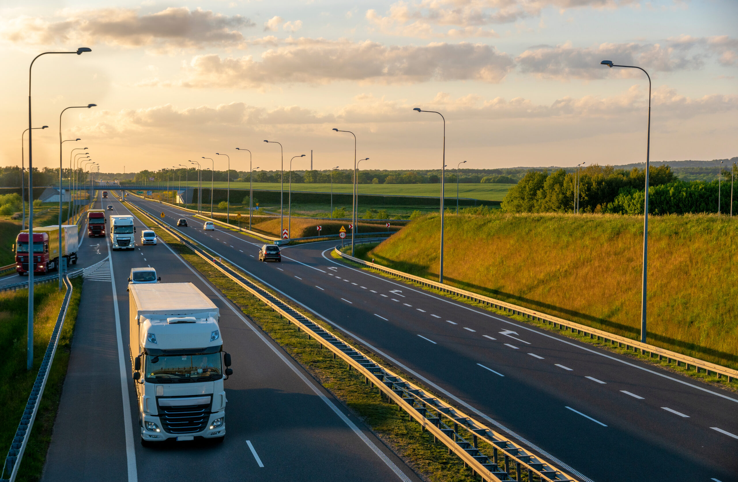 Lorries travelling along a motorway at sunset